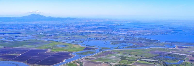 Aerial view looking west at Bacon Island, part of the Sacramento-San Joaquin River Delta in San Joaquin County, California. Mount Diablo is visible on the horizon.